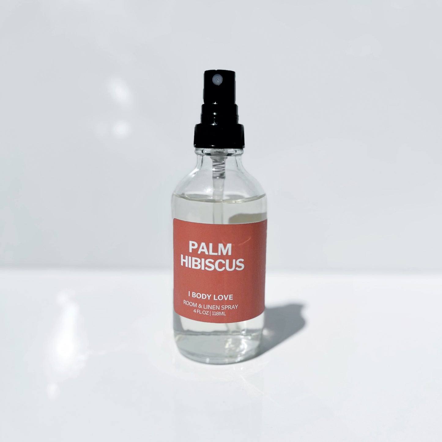 Clear spray bottle Palm Hibiscus label on a Red background