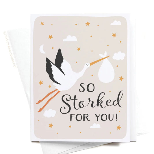 Greeting card with a stork illustration and text 'So Storked For You!' on a beige background.