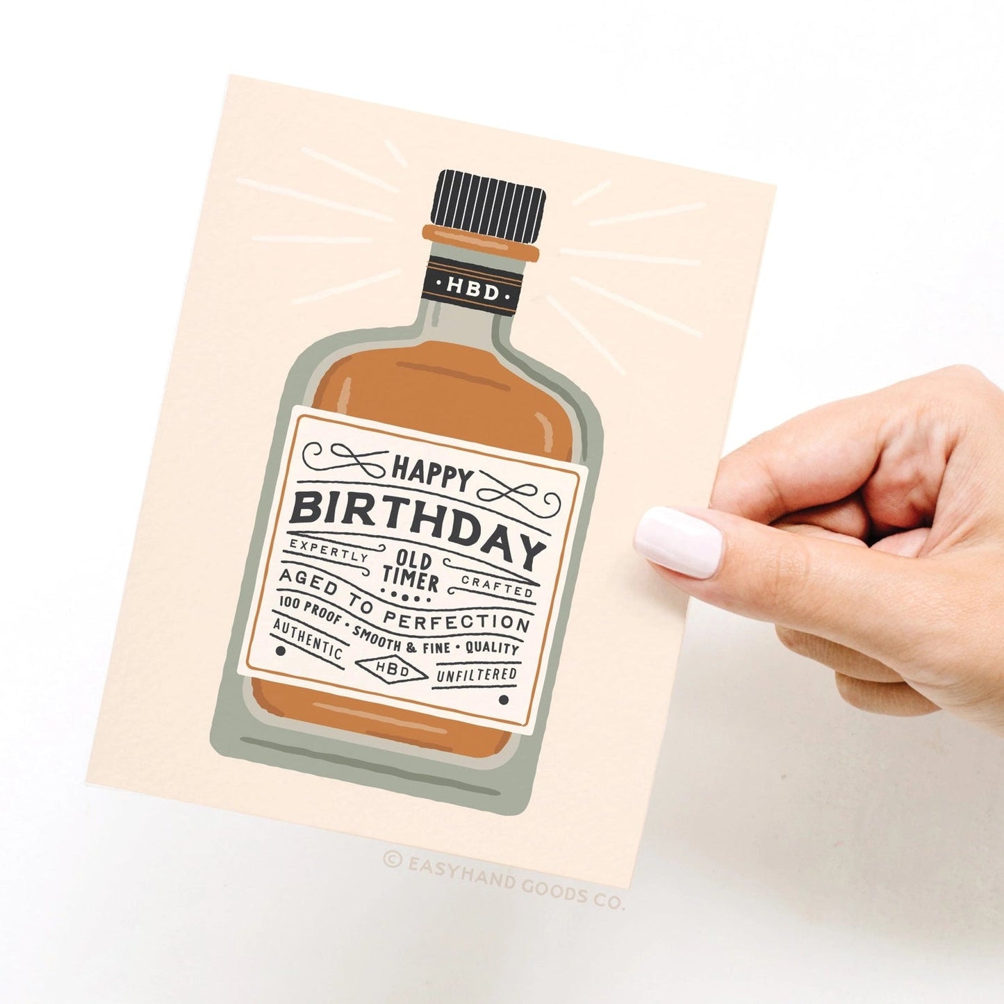 Hand holding a birthday card with a bottle design on a white background