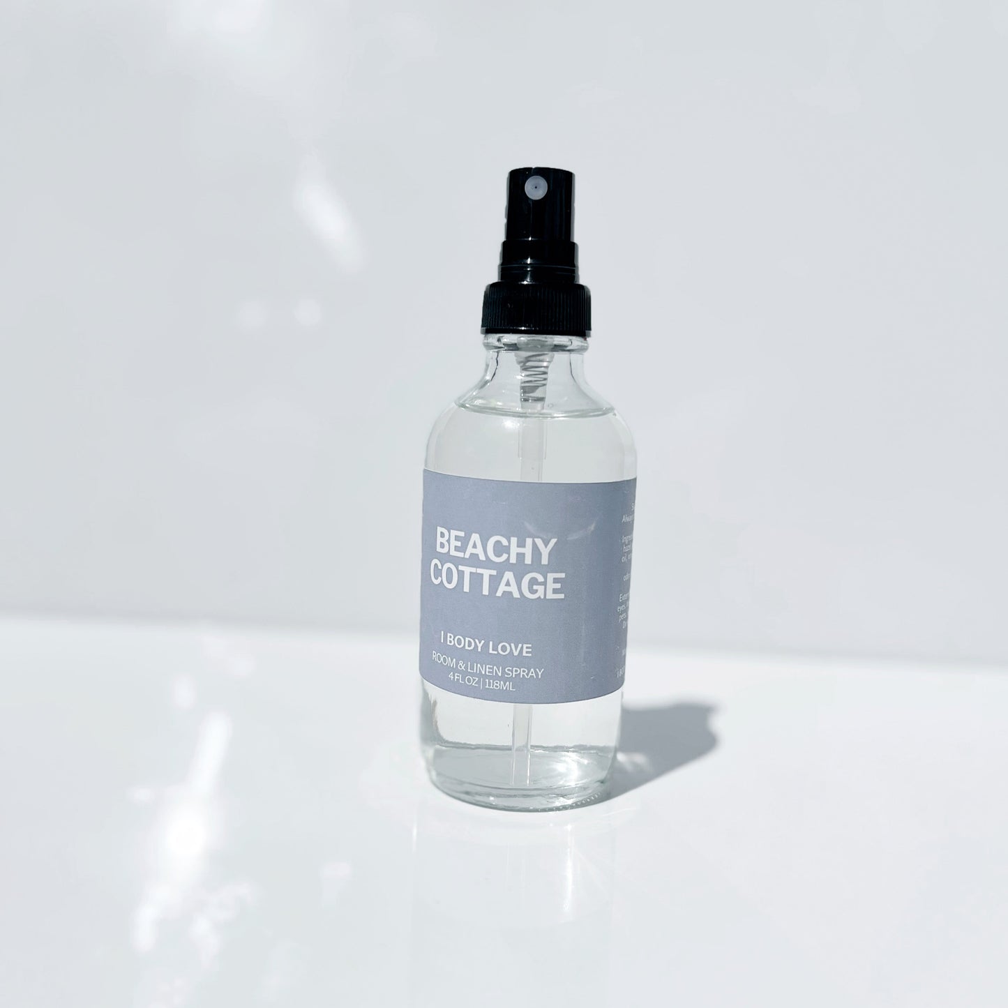 Clear spray bottle labeled 'Beachy Cottage' on a white background