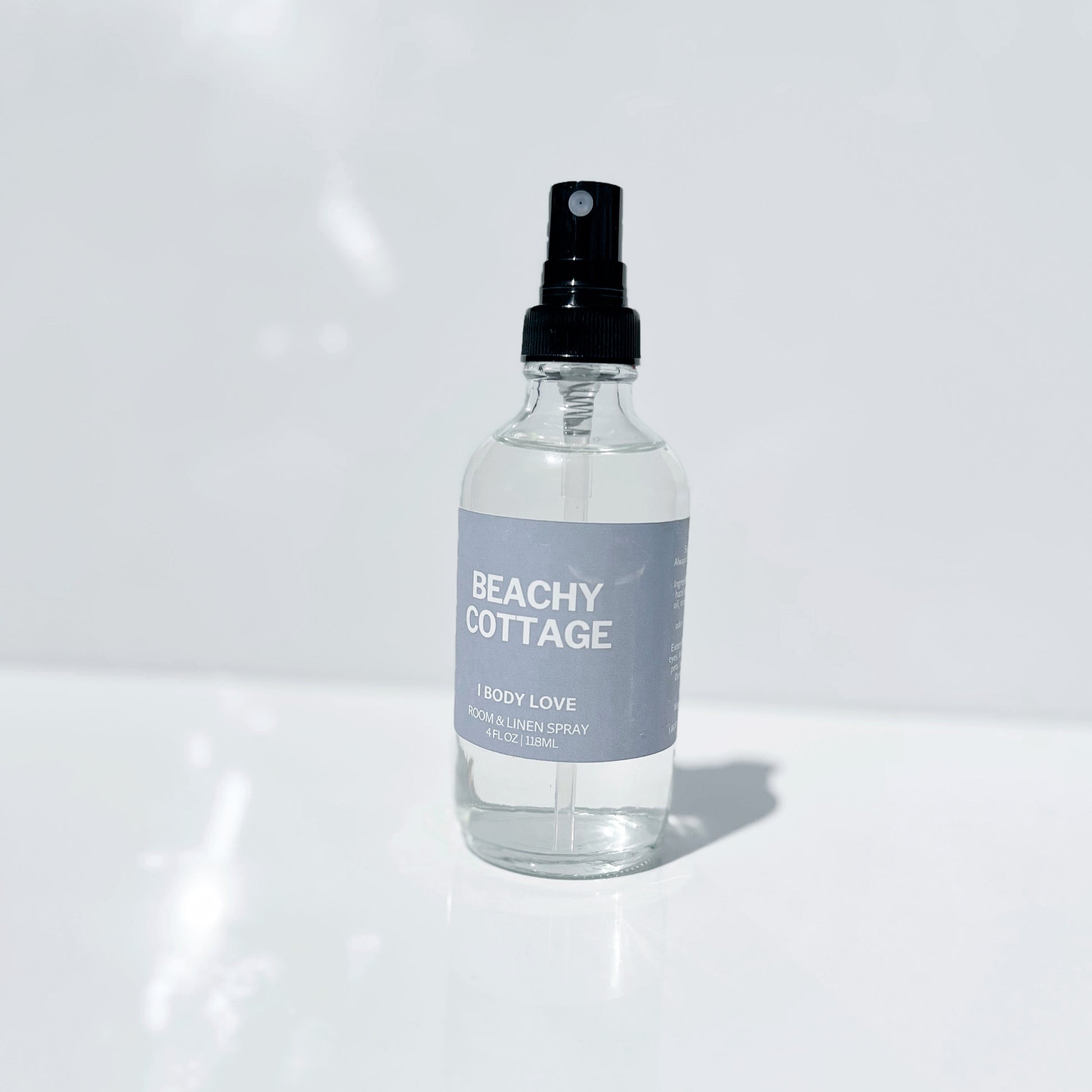 Clear spray bottle labeled 'Beachy Cottage' on a white background