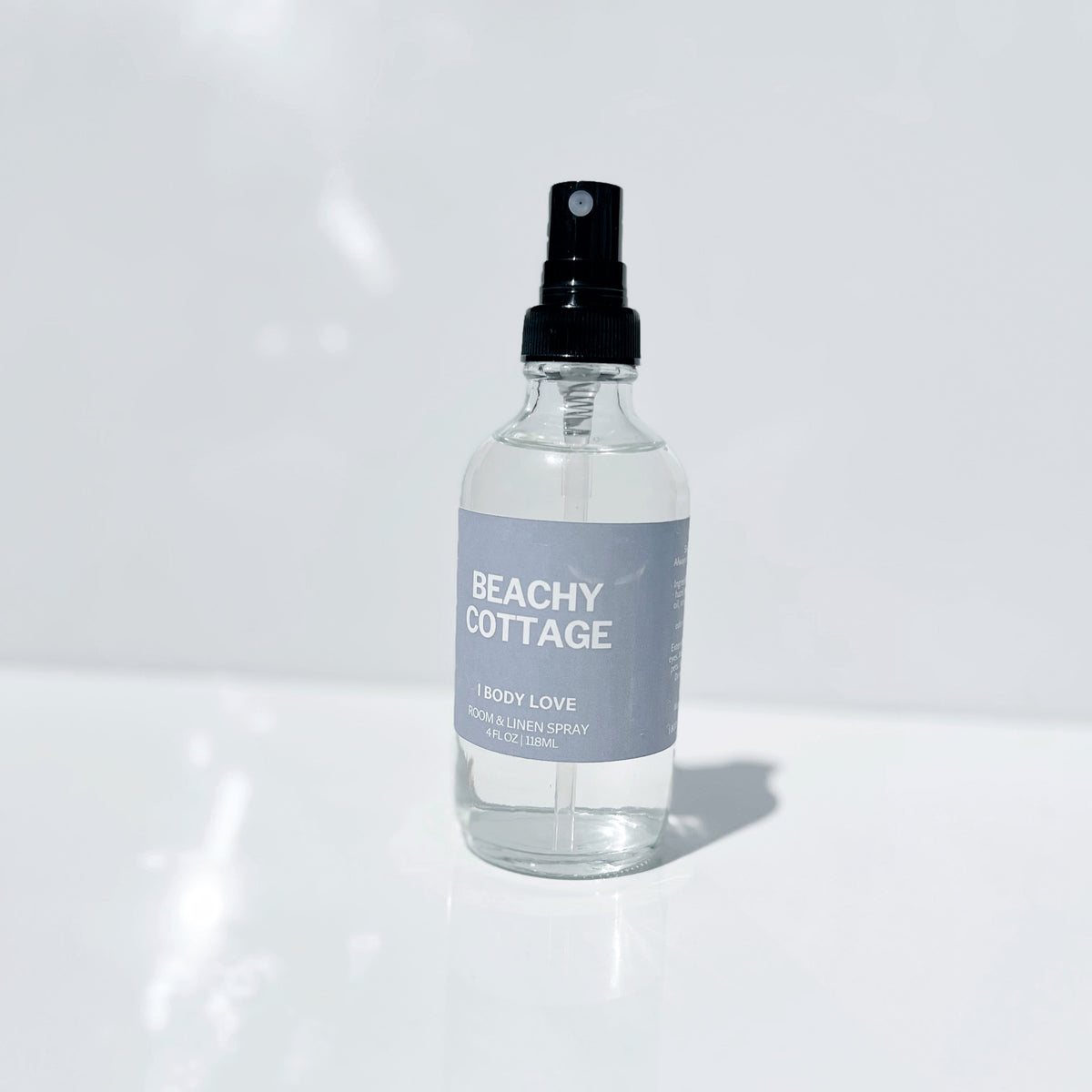 Clear spray bottle labeled 'Beachy Cottage' on a white background