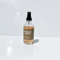 Clear spray bottle labeled 'Pistachio Cream' on a white surface