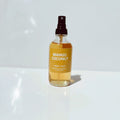 Mango Coconut body love spray bottle on a white surface