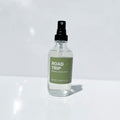 Clear spray bottle labeled 'Road Trip' on a white background