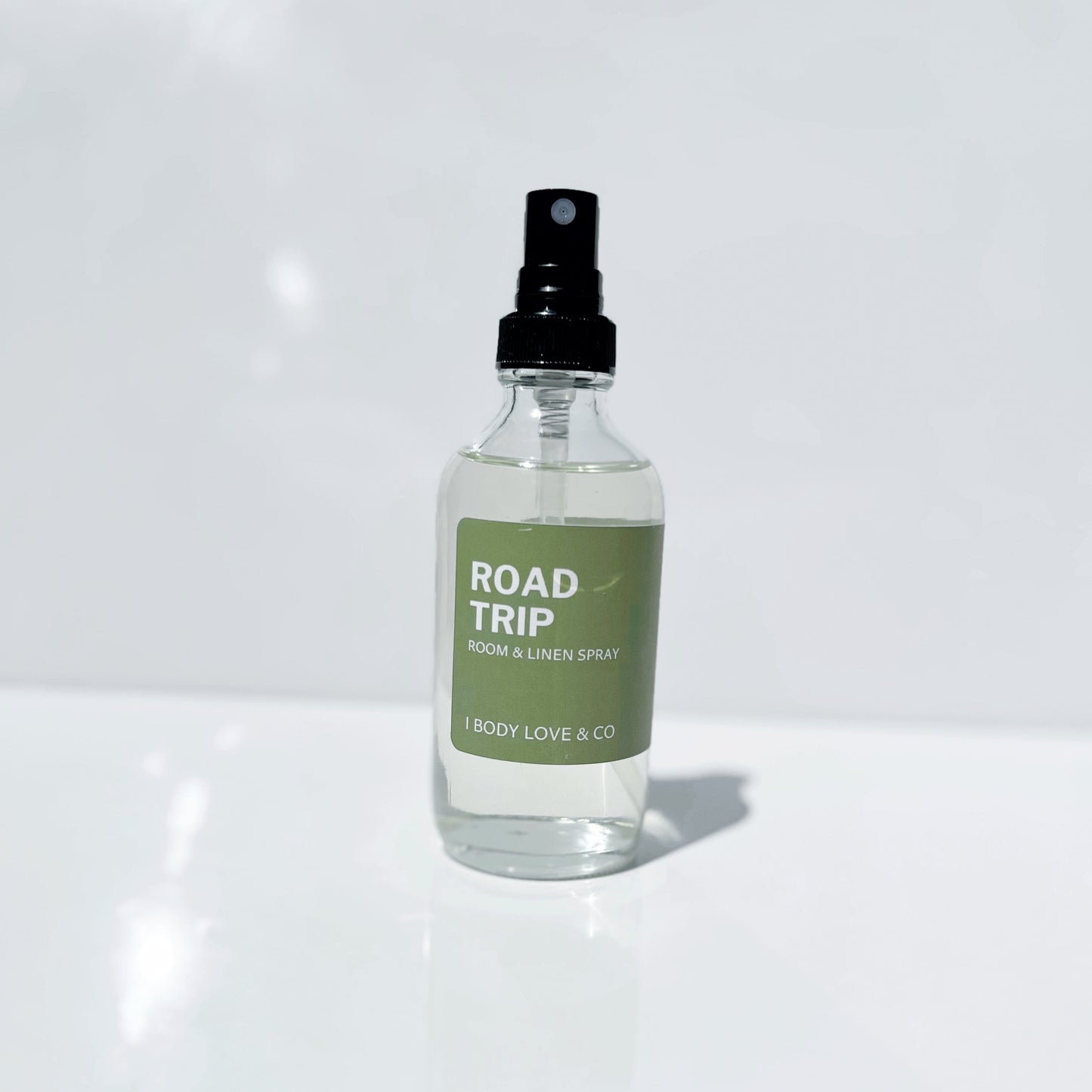 Clear spray bottle labeled 'Road Trip' on a white background