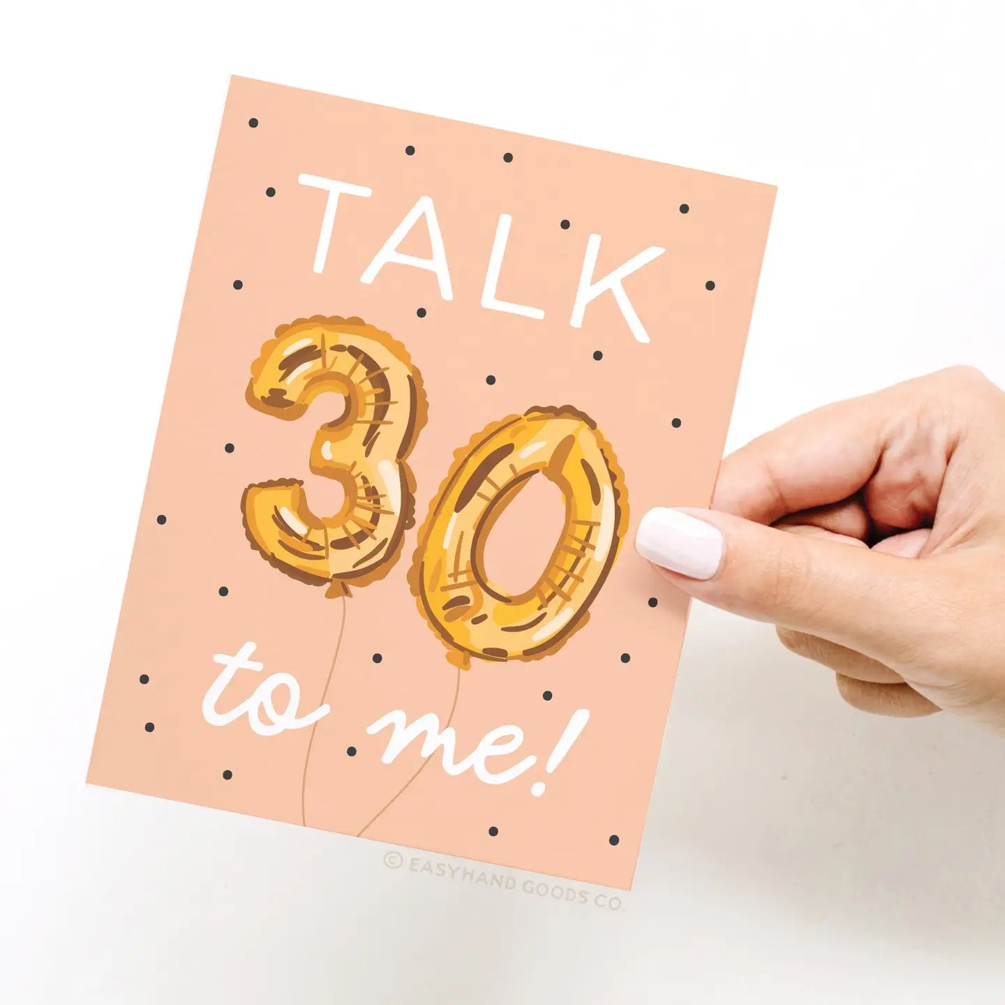 Card with 'Talk 30 to me!' text and gold balloon design, held by a hand.
