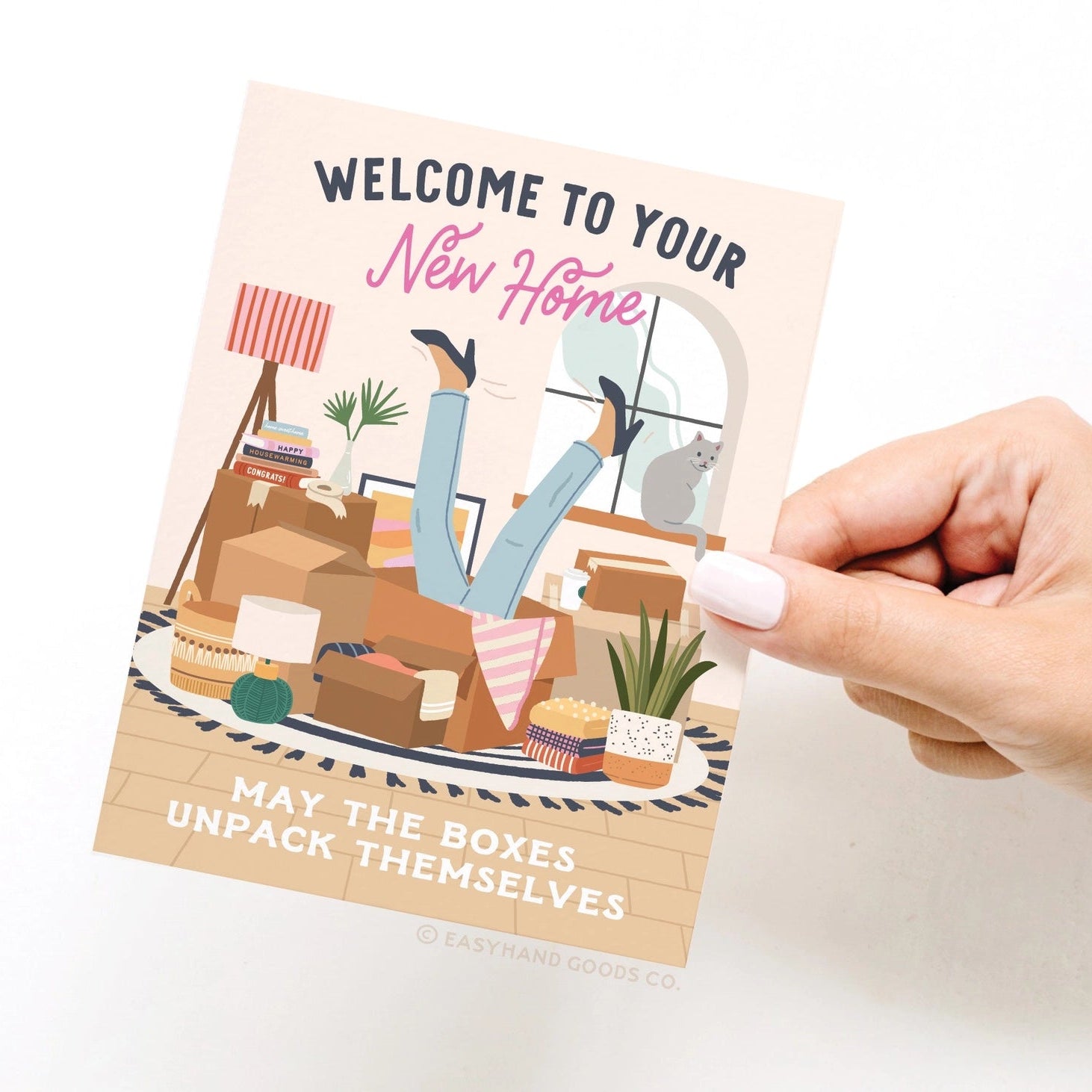 Hand holding a 'Welcome to Your New Home' card with illustrations of a living room and text.