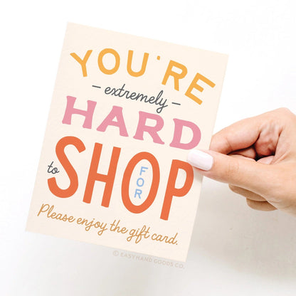 Hand holding a gift card with colorful text on a white background